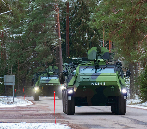 Kaksi panssariajoneuvoa ajamassa kohti kameraa maantiellä.