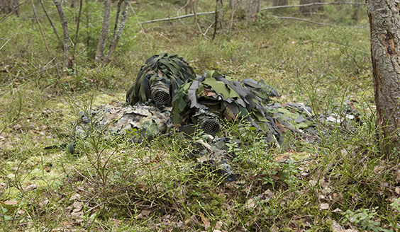 Kahden taistelijan tarkka-ampujapartio tuliasemassa naamiovarusteissa