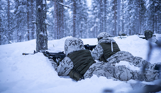 Two soldiers in a snowy forest.