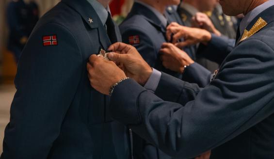A badge is attached to the students' chests.