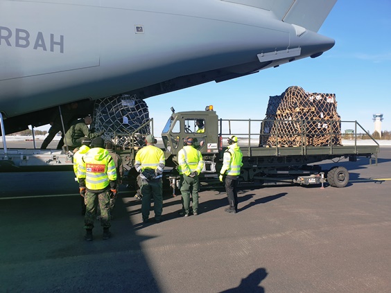 Soldiers are observing cargo being unloaded from a transport aircraft’s rear ramp with a transporter. Photo by Finnish Defence Forces.