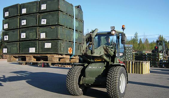A wheel loader lifting a pallet of green metallic containers. Photo by Finnish Defence Forces.