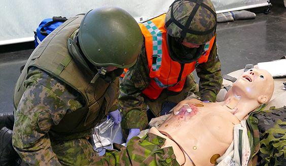 Soldater övar sig i akutvård med hjälp av en docka. Bild Försvarsmakten.