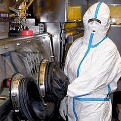 En person iklädd skyddsdräkt arbetar i ett laboratorium. Bild Försvarsmakten.