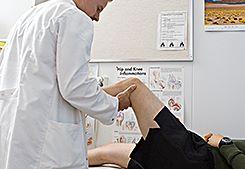 En läkare undersöker en bevärings knä. Bild Försvarsmakten, Jarno Kovamäki.